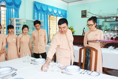  Trần Ngọc Phước (thứ 2 từ phải qua) trao đổi nghiệp vụ nhà hàng với các sinh viên trong lớp.