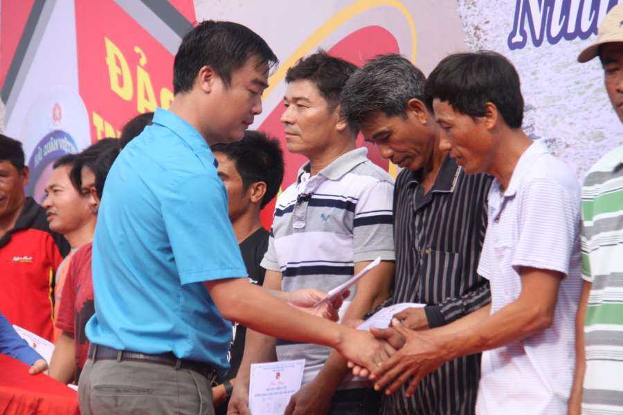 Đồng chí Nguyễn Tấn Tuân và đồng chí Nguyễn Văn Nhuận trao tặng thẻ bảo hiểm y tế cho ngư dân.