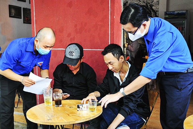 Các đoàn viên, thanh niên TP. Nha Trang tuyên truyền, hướng dẫn người dân cài đặt ứng dụng Bluezone trên điện thoại.