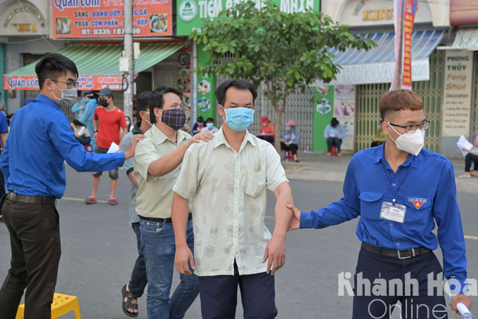 Tại điểm tiêm ở số 26 Hoàng Hoa Thám, TP. Nha Trang các tình nguyện viên tham gia hỗ trợ người khiếm thị để làm thủ tục trước tiêm.