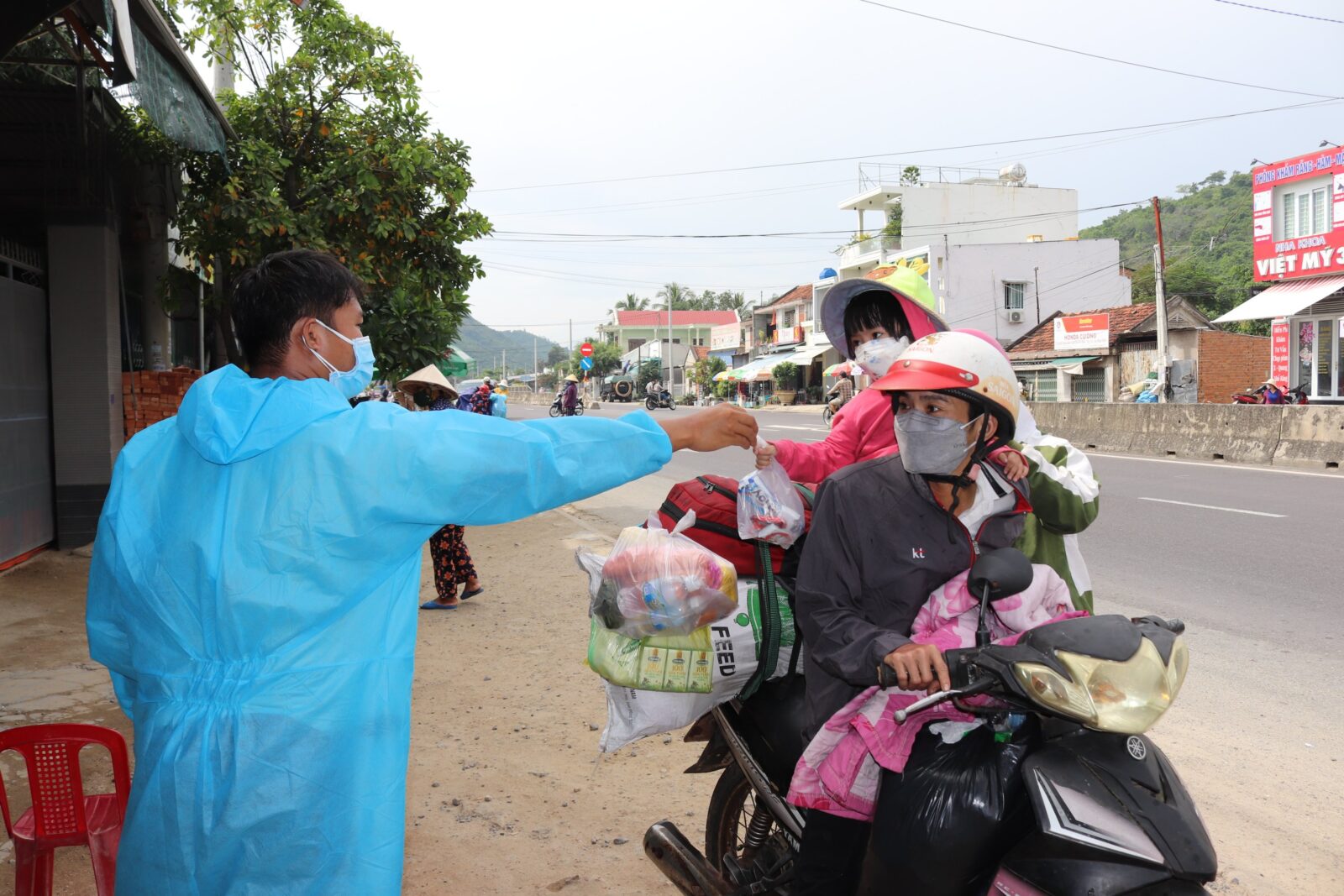 Vợ chồng anh La Văn Cường, chị Trần Thị Huệ và con gái 3 tuổi nhận quà hỗ trợ trên đường về quê Bình Định.