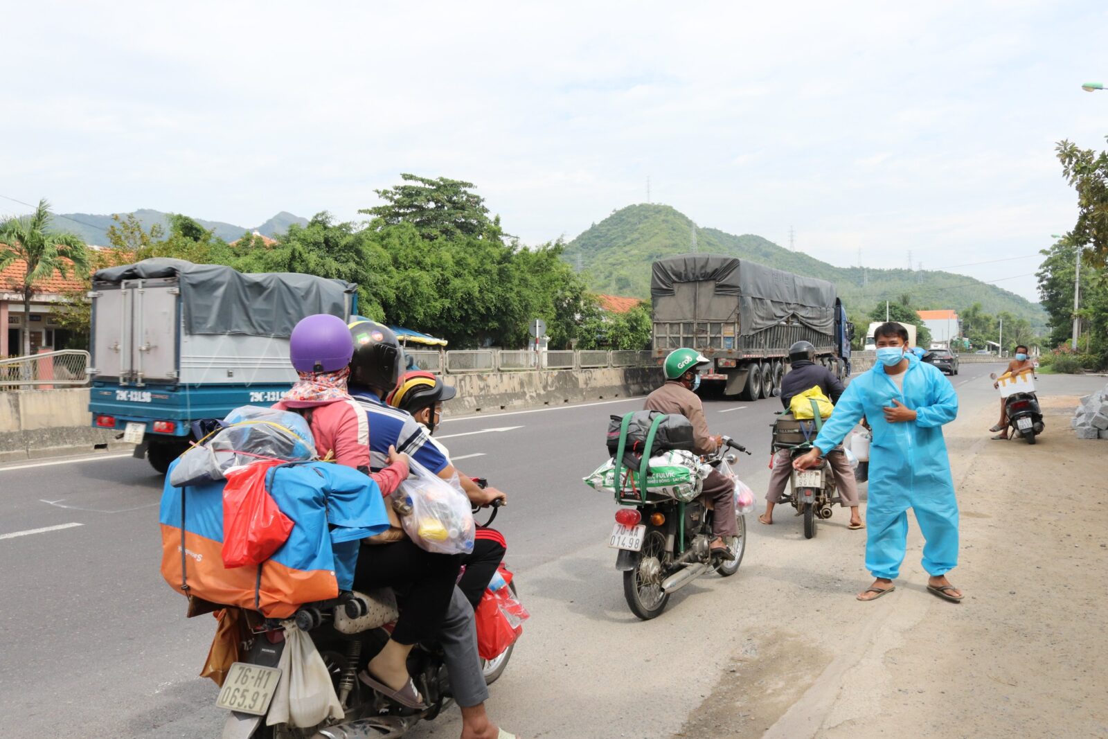 Những đoàn xe của người lao động về quê dừng lại trên Quốc lô 1 (qua địa phận tỉnh Khánh Hòa) để nhận cơm, nước.